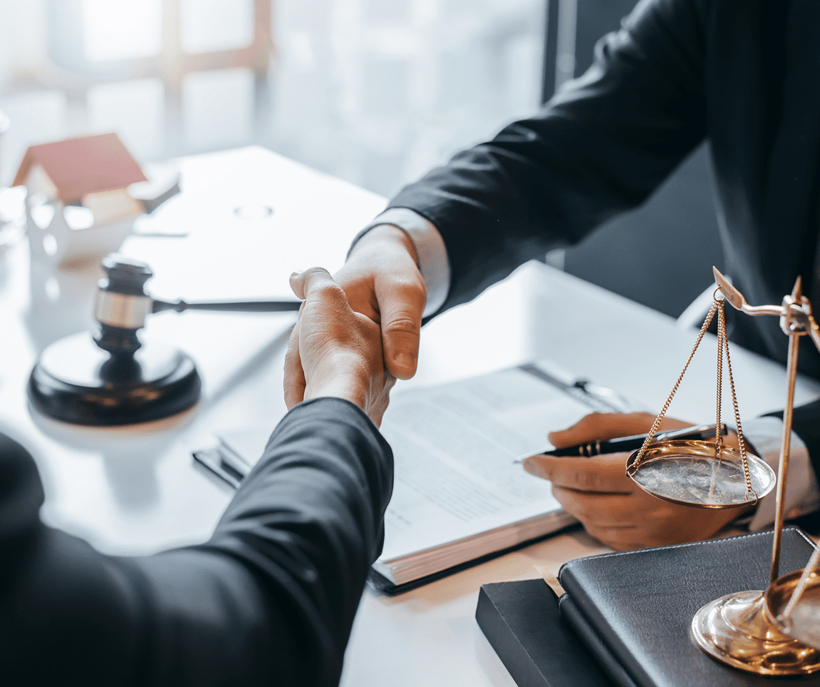 Handshake over legal documents and scales.